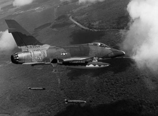 Um F-100D lança bombas sobre posições inimigas no Vietnã do Sul. Além do Sudeste Asiático, ele atuou também com as forças turcas em Chipre. (Foto: britannica.com)